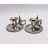 A pair of late Victorian silver chambersticks, with gadrooned borders and matching extinguishers,