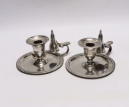 A pair of late Victorian silver chambersticks, with gadrooned borders and matching extinguishers,