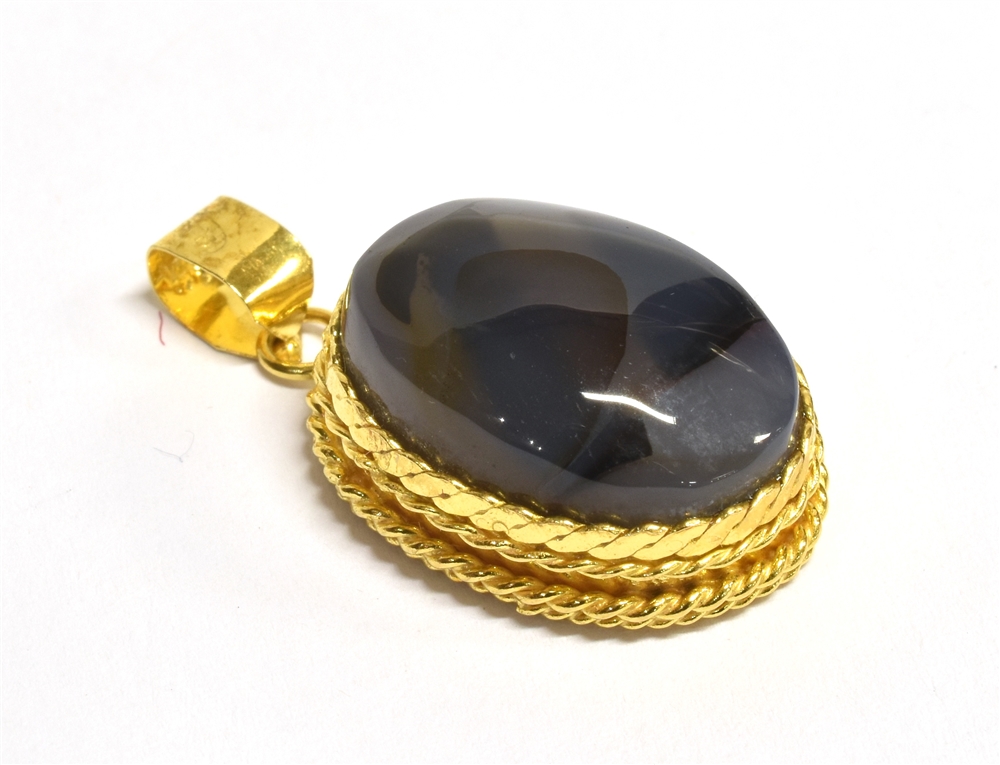 A YEMENI BLUE AQEEQ STONE PENDANT PIECE The oval blue aqeeq stone mounted in patterned yellow