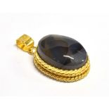 A YEMENI BLUE AQEEQ STONE PENDANT PIECE The oval blue aqeeq stone mounted in patterned yellow
