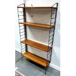 A BAY OF LADDERAX STYLE SECTIONAL SHELVING comprising two one-legged metal uprights, and four teak