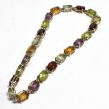 STAMPED 750 MULTI GEM SET BRACELET The bracelet set with faceted oval alternating red, purple,