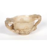A CHINESE JADE TWIN HANDLED LIBATION CUP the handles modelled as chilong with bifurcated tails,