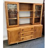 AN ERCOL GOLDEN DAWN DRESSER the upper sectino with pair of glazed doors enclosing shelves, base