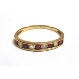 CHANNEL SET DIAMOND AND RUBY DRESS RING The tapered unmarked yellow metal band set with four round