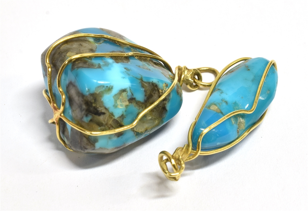 TWO MIDDLE EASTERN TURQUOISE MATRIX PENDANTS The two pendants held in fine yellow metal wire with