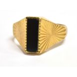 A VINTAGE 9CT GOLD SIGNET RING vertical rectangular black hardstone bezel, wide star patterned