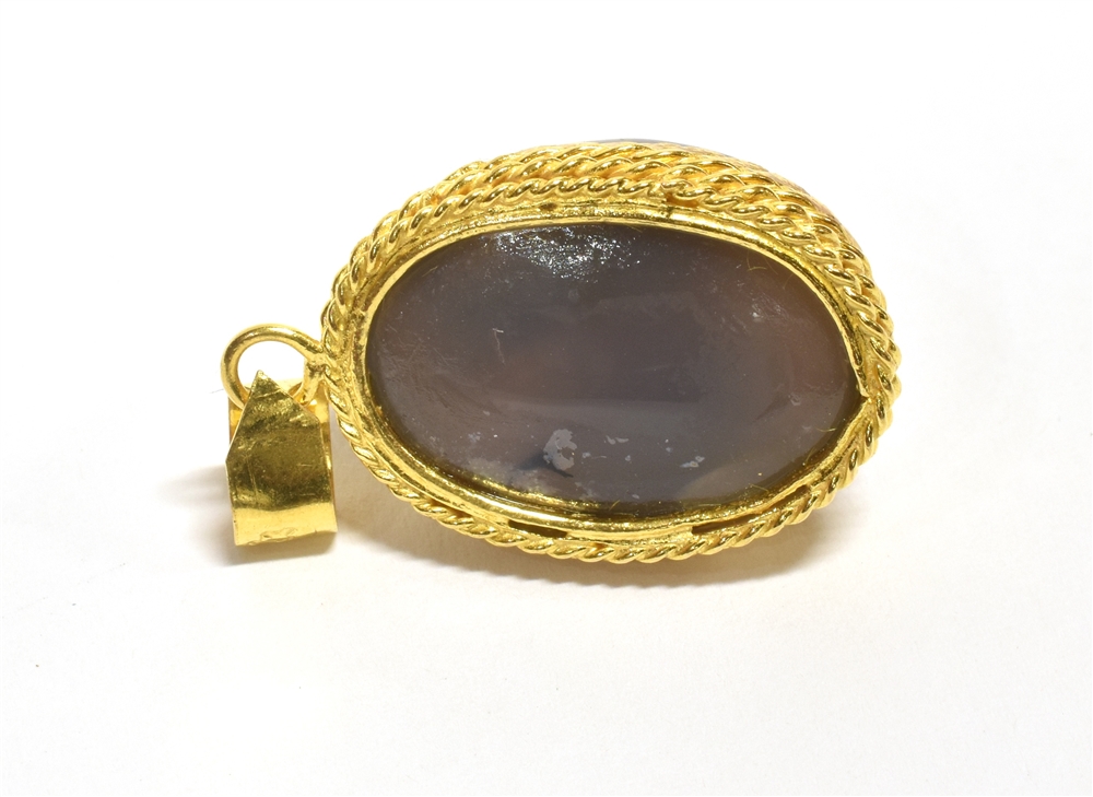 A YEMENI BLUE AQEEQ STONE PENDANT PIECE The oval blue aqeeq stone mounted in patterned yellow - Image 2 of 2