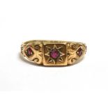 A VINTAGE 9CT GOLD RUBY GYPSY RING The ring set with three round cut rubies, the central ruby star