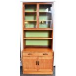 A G-PLAN TEAK WALL UNIT the upper section with glazed doors enclosing two adjsutable shelves above