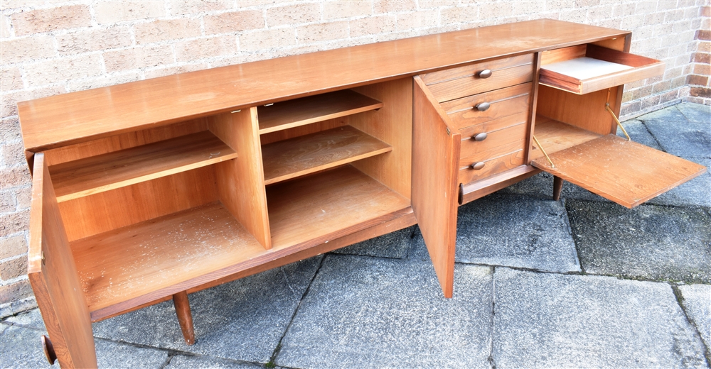 A 1960S TEAK SIDEBOARD fitted with four drawers flanked to one side with drop-down cupboard - Image 2 of 3