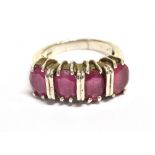 A RUBY FOUR STONE STATEMENT RING The set with four faceted oval rubies (purplish) measuring approx 8