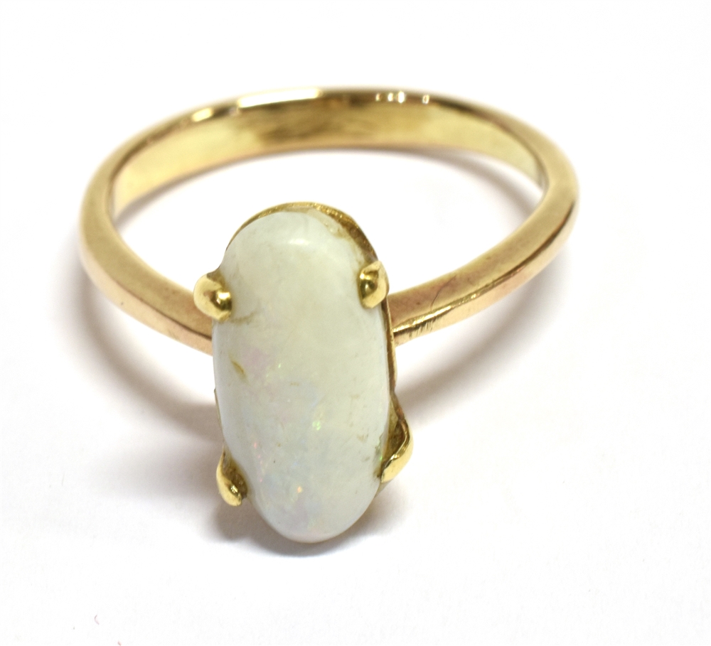 WHITE PINFIRE OPAL RING The oval opal measuring 1.3 x 0.6cm on an unmarked yellow metal shank with