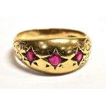A 9CT GOLD RUBY GYPSY RING The ring set with three star set rubies, engraved pattern to the