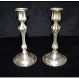 A MATCHED PAIR OF GEORGE V SILVER CANDLE STICKS The weighted candlesticks with fluted stems,