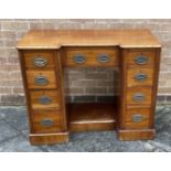 A SMALL MAHOGANY INVERTED BREAKFRONT KNEEHOLE DESK fitted with an arrangement of nine drawers,