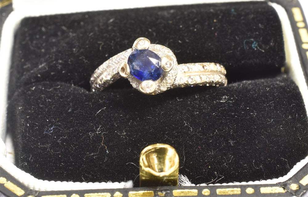 A STAMPED 18K SAPPHIRE AND DIAMOND CROSS OVER RING The ring in white metal and centrally set with - Image 2 of 6
