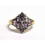 A 9CT GOLD AMETHYST CLUSTER RING The lozenge shaped cluster set with nine round cut light