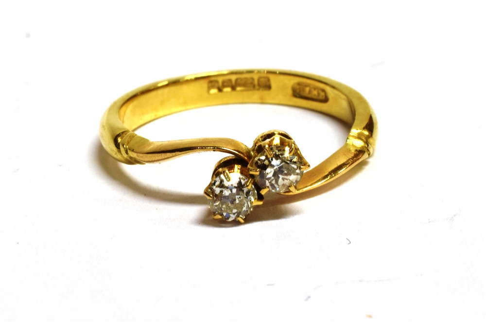 AN 18CT GOLD, DIAMOND TWO STONE CROSSOVER RING The two diamonds each measuring approx 2mm in