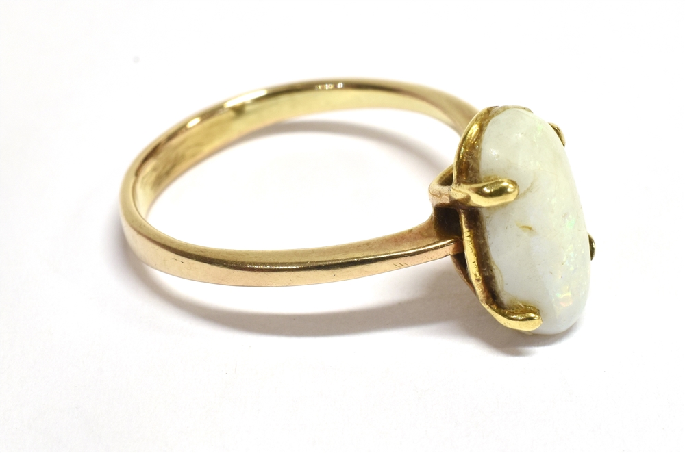 WHITE PINFIRE OPAL RING The oval opal measuring 1.3 x 0.6cm on an unmarked yellow metal shank with - Bild 2 aus 3