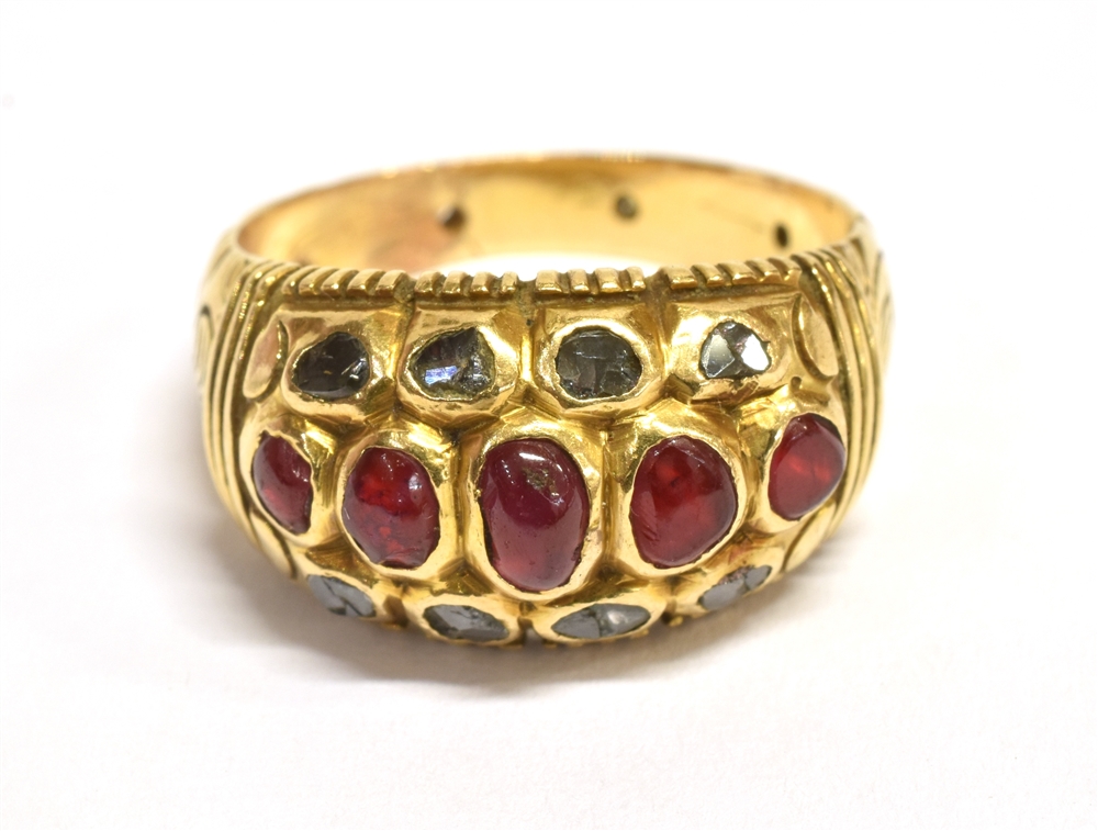 A RUBY AND SAPPHIRE CLUSTER RING The horizontal dome cluster set with five graduated oval rubies and