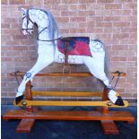 A CARVED WOOD ROCKING HORSE the side glancing head with inset glass eyes, flared nostrils and an