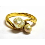 AN 18CT GOLD BLISTER PEARL AND SHELL CROSS OVER RING The ring set with one blister pearl and one