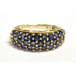 A 9CT GOLD SAPPHIRE CLUSTER RING The cluster made up of a triple row of small near black