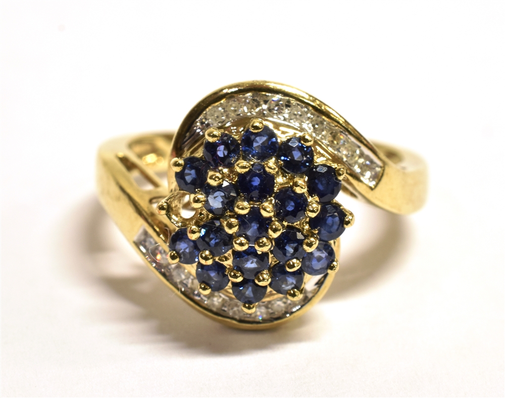QVC 9CT GOLD, GEM SET WRAP OVER CLUSTER RING The cluster set with blue gemstones with a diamond