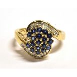 QVC 9CT GOLD, GEM SET WRAP OVER CLUSTER RING The cluster set with blue gemstones with a diamond