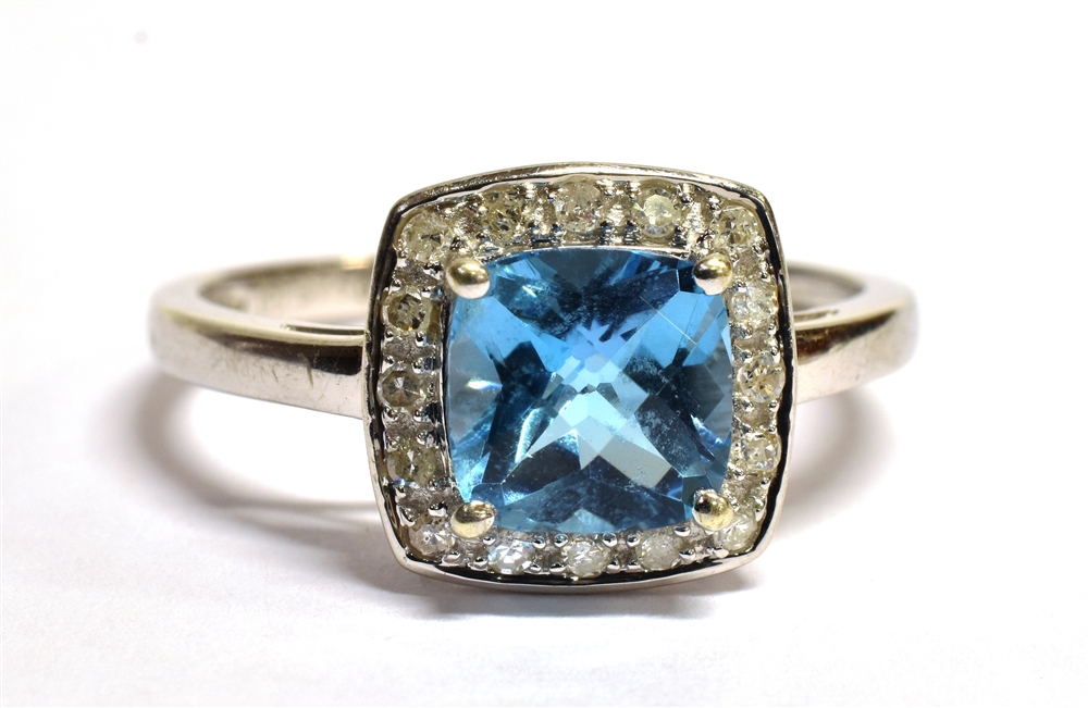 9CT WHITE GOLD DIAMOND CLUSTER RING The ring set with a cushion cut faceted sky blue gemstone