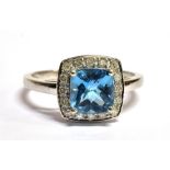 9CT WHITE GOLD DIAMOND CLUSTER RING The ring set with a cushion cut faceted sky blue gemstone