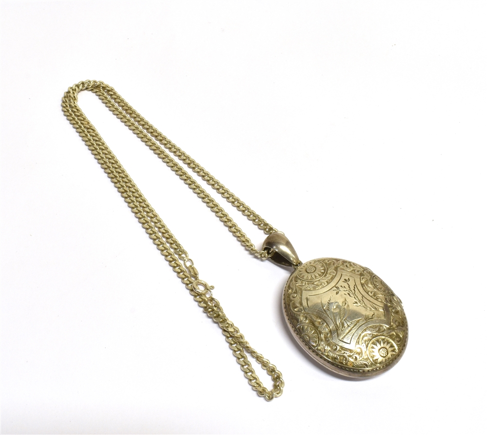 A LATE VICTORIAN SILVER LOCKET WITH CHAIN The large oval locket with chased floral design