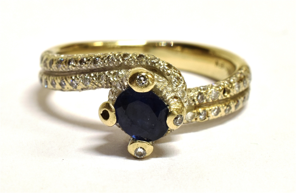 A STAMPED 18K SAPPHIRE AND DIAMOND CROSS OVER RING The ring in white metal and centrally set with - Bild 6 aus 6