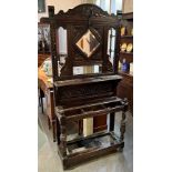 AN EARLY 20TH CENTURY OAK HALLSTAND with carved decoration, the back inset with bevelled mirror,