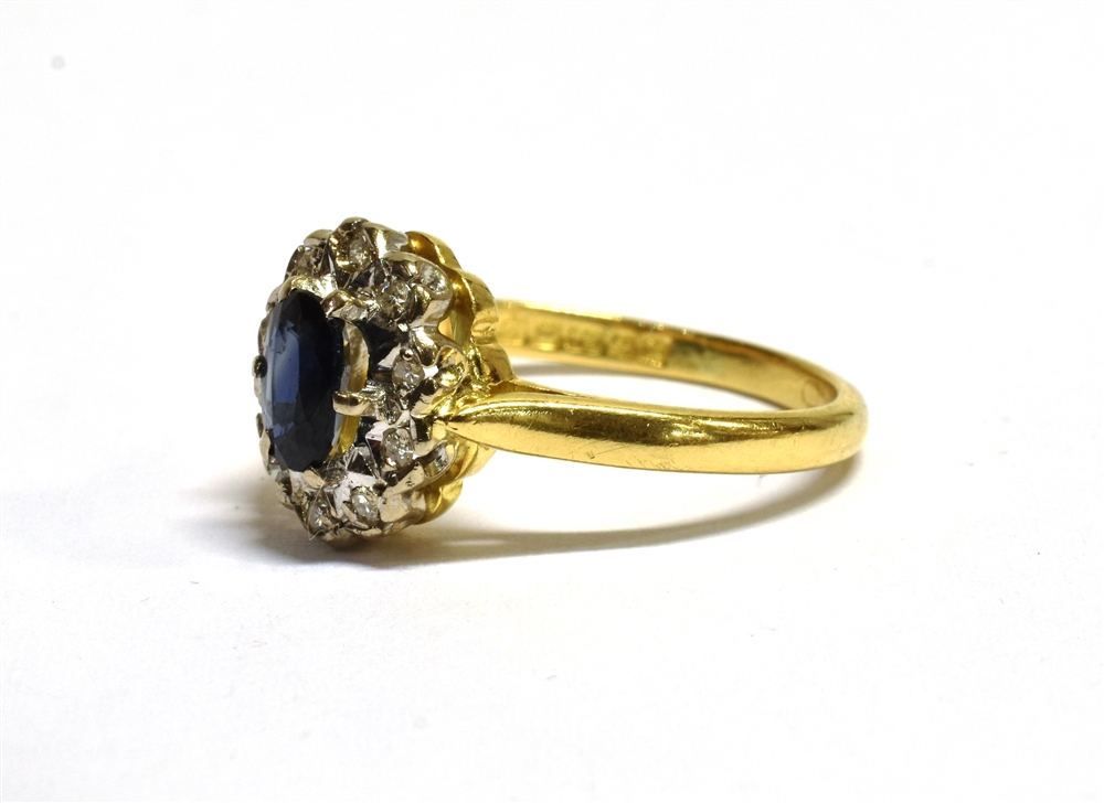18CT GOLD SAPPHIRE CLUSTER RING The cluster measuring 1.1 x 0.9cm and set with a central oval blue - Image 3 of 4