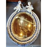 A CONTINENTAL OVAL WALL MIRROR probably Sitzendorf, the hard paste porcelain framed applied with