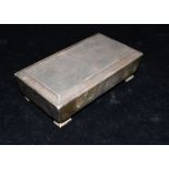 A VINTAGE SILVER COATED FOOTED BOX the box pf plain form with canted border to the lid, engine