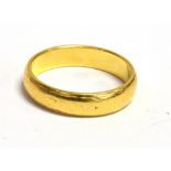 A 22CT GOLD BAND RING Band width 4mm, ring size K, worn hallmark, possibly Birmingham, weight 4g