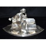 A SILVER PLATED INKWELL STAND Featuring a seated figural lady with letter and envelope, one well, no