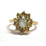MARKED 9CT VINTAGE FLOWER HEAD RING The flower head comprising of an oval pale blue gem surrounded