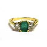 EMERALD AND DIAMOND THREE STONE DRESS RING Together with an assessment stating, central
