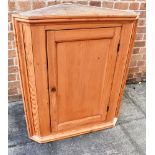 A PITCH PINE HANGING CORNER CUPBOARD the panelled door enclosing two internal shelves, 78cm wide