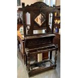 AN EARLY 20TH CENTURY OAK HALLSTAND with carved decoration, the back inset with bevelled mirror,