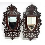 A PAIR OF SHIELD SHAPED MAHOGANY WALL MIRRORS with mahogany open fret carved frames, 36cm x 66cm