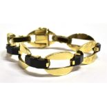 A STAMPED 585 YELLOW METAL AND BLACK RESIN PANEL BRACELET The bracelet comprised of oval openwork,