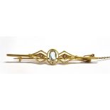 MARKED 15CT EARLY 20TH CENTURY BAR BROOCH The brooch centrally set with an oval blue paste stone