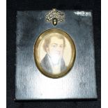 AN OVAL PORTRAIT MINATURE OF A REGENCY GENTLEMAN in reproduction papier mache type frame with