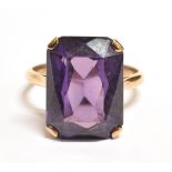 PURPLE SAPPHIRE COCKTAIL RING The single step cut stone measuring 1.6 x 1.2cm on a yellow metal