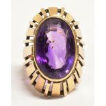 GEM SET STATEMENT RING The large faceted oval purple gem measuring 1.8 x 1.2cm approx. in a semi